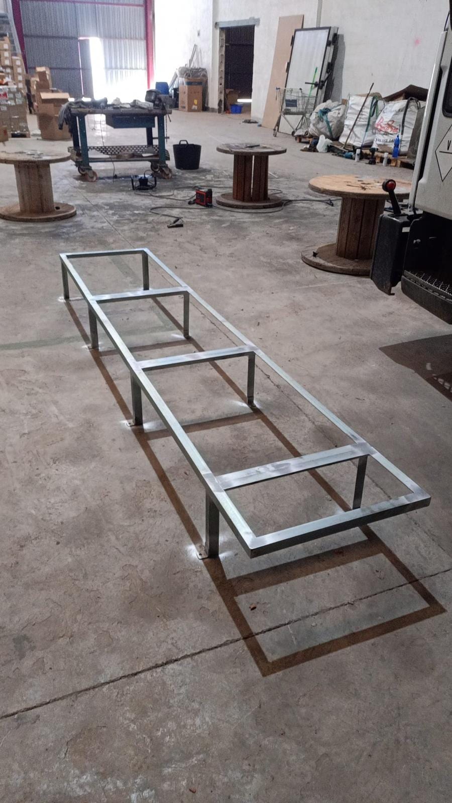 bastidor de tubo cuadrado galvanizado con patas, en el suelo de la nave
