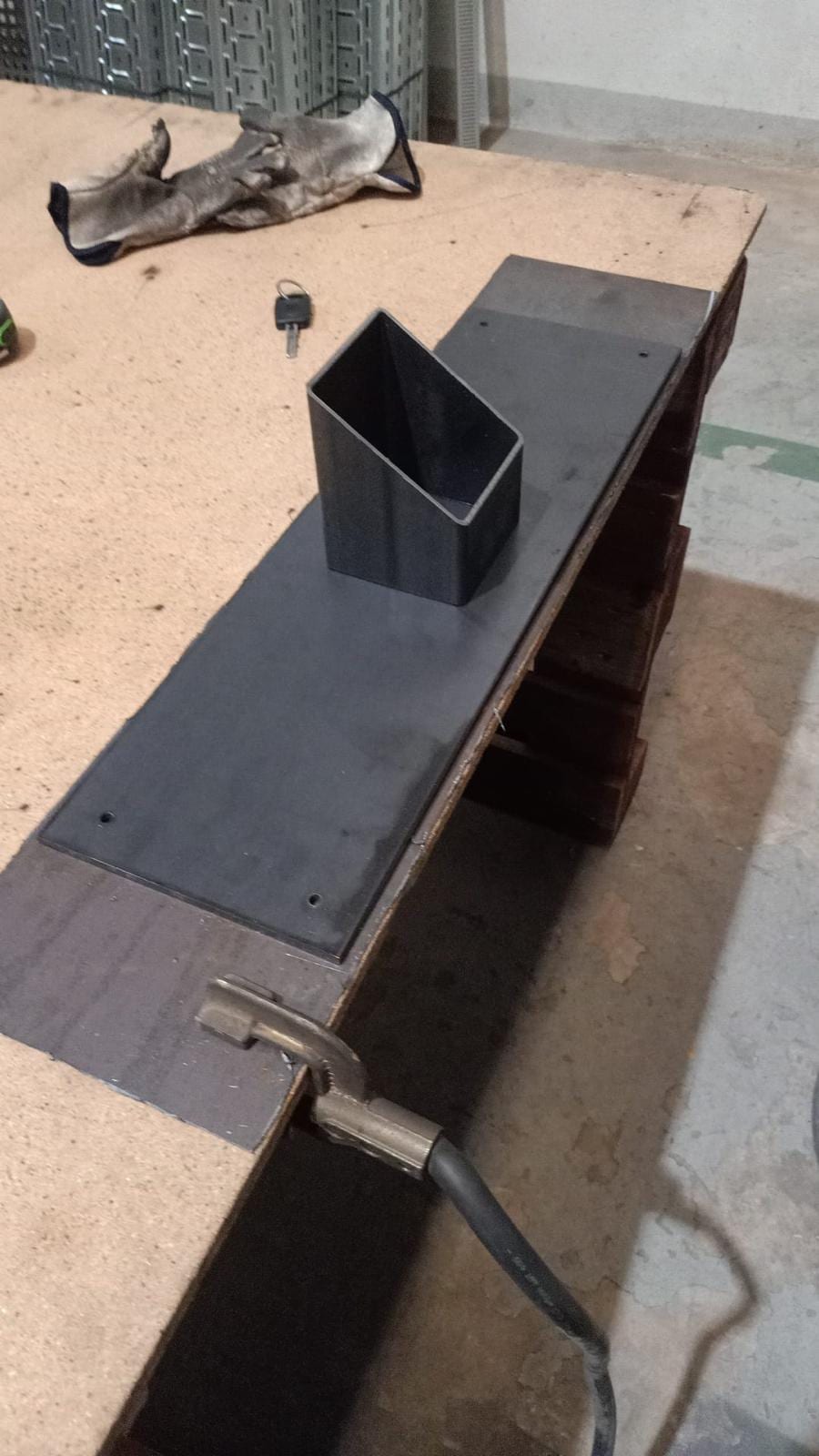 placa base con tubo cuadrado cortado a inglete sobre la mesa de trabajo