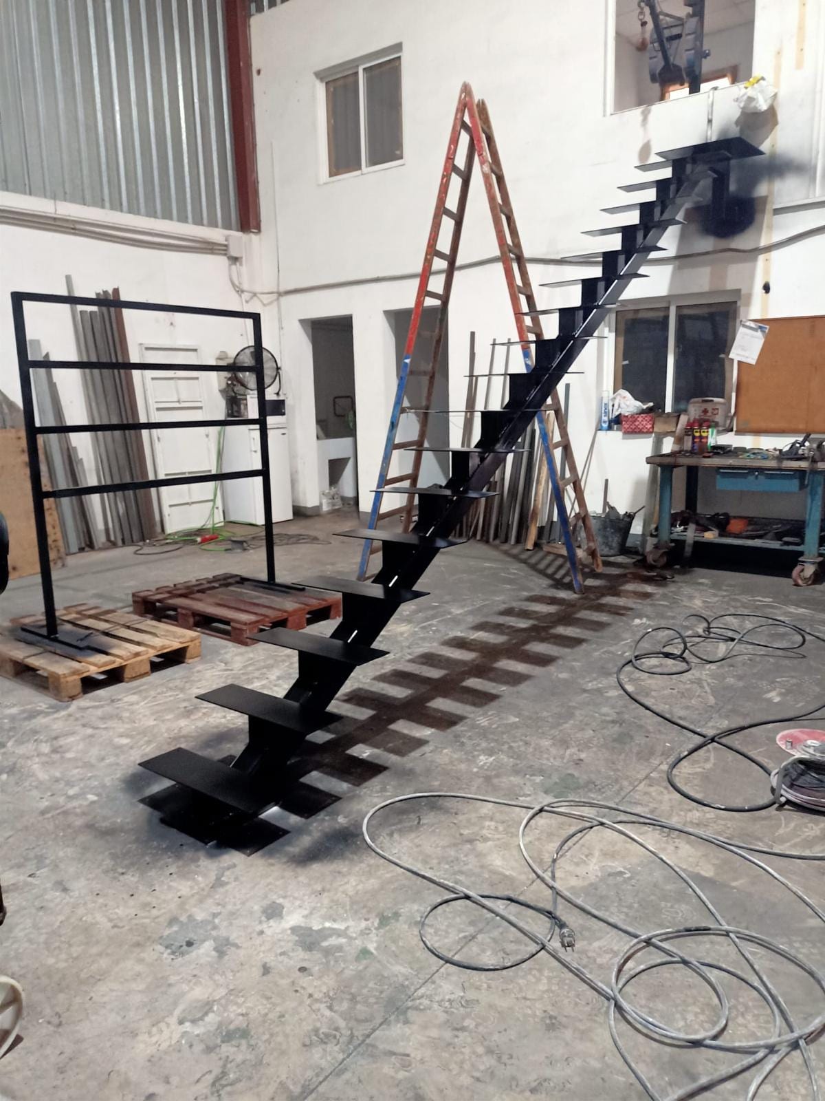 escalera de zanca central ya pintada en negro, montada en la nave